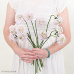 Bride wearing a wedding dress and holding an elegant bouquet of flowers