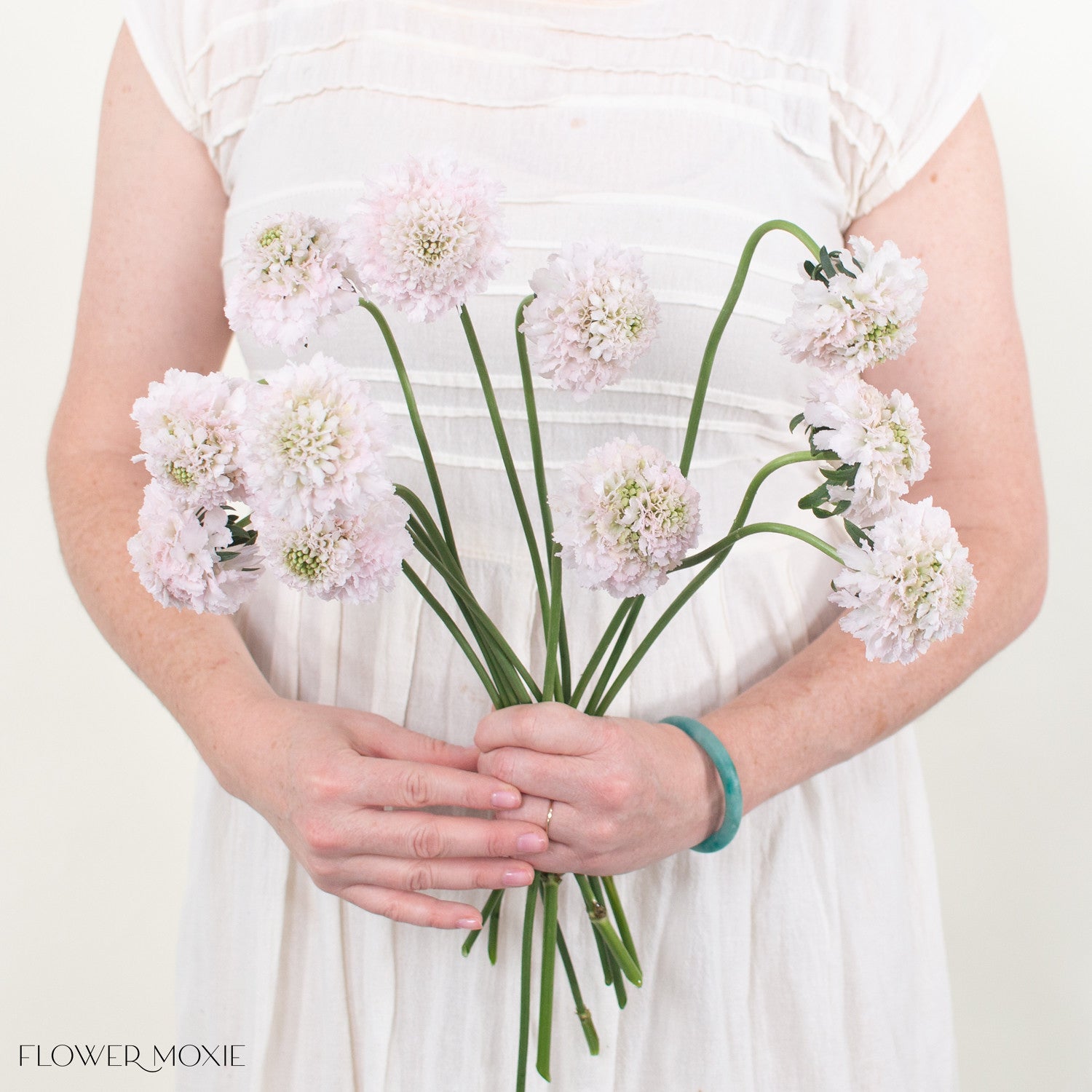 Bride wearing a wedding dress and holding an elegant bouquet of flowers