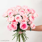 Bouquet of pink roses held by a hand on a light background, with 'Flower Moxie' branding.