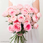 Bouquet of pink roses held by a person against a plain background