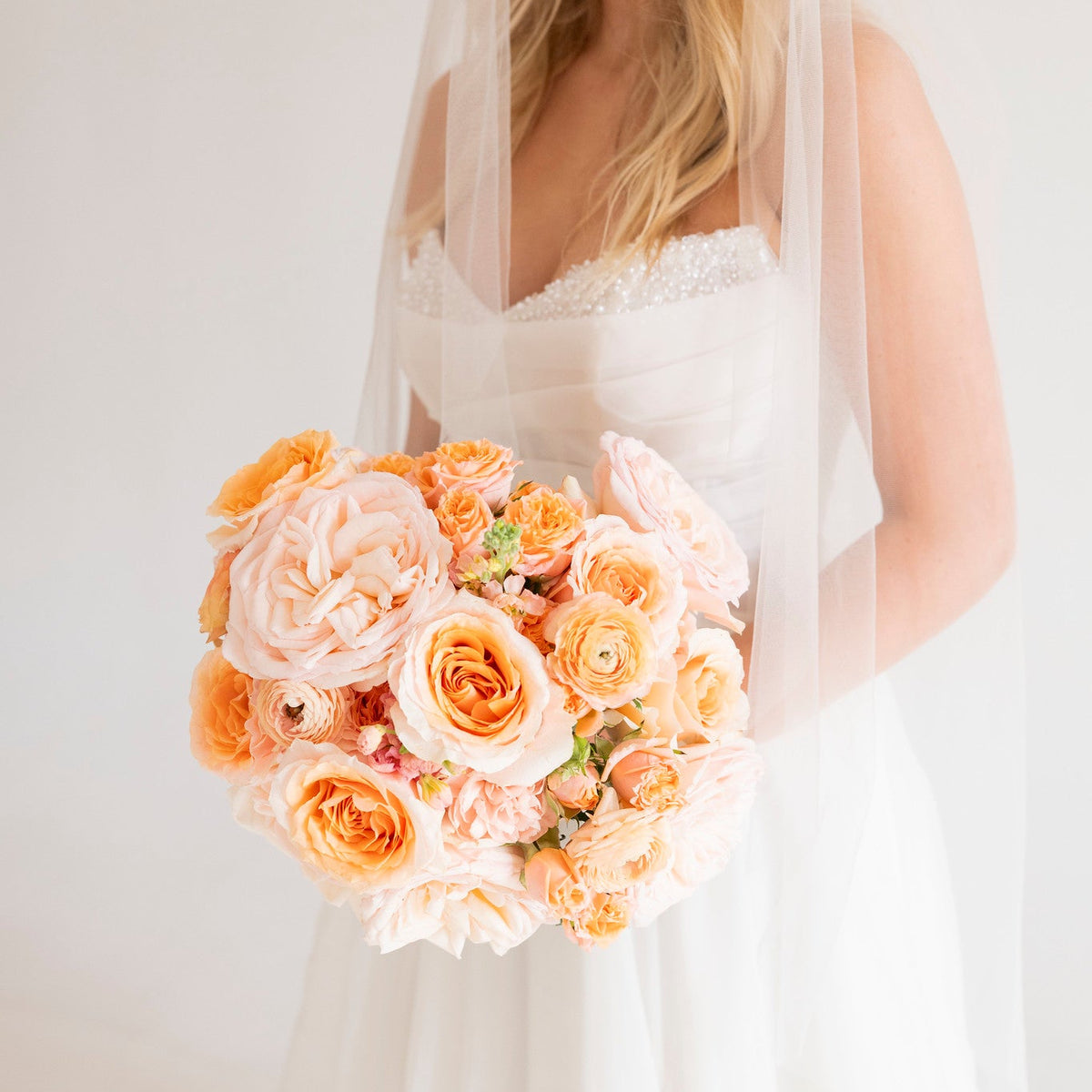 Bride holding an all peach bridal bouquet