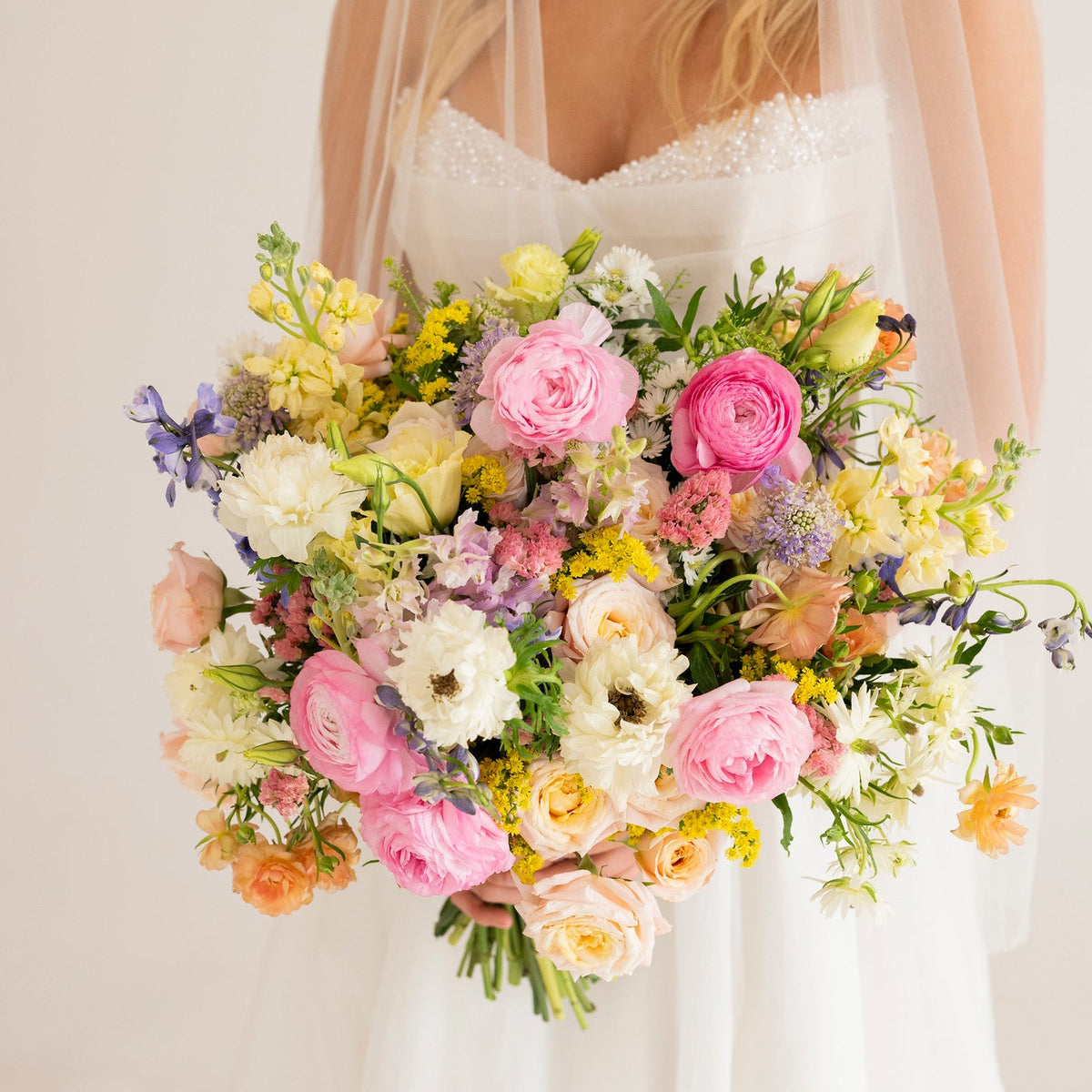bride holding a bouquet of wildflowers