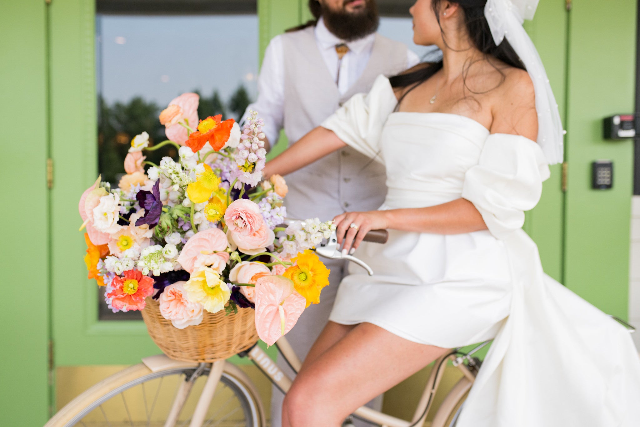 Woman riding a bycicle with flowers on the basket