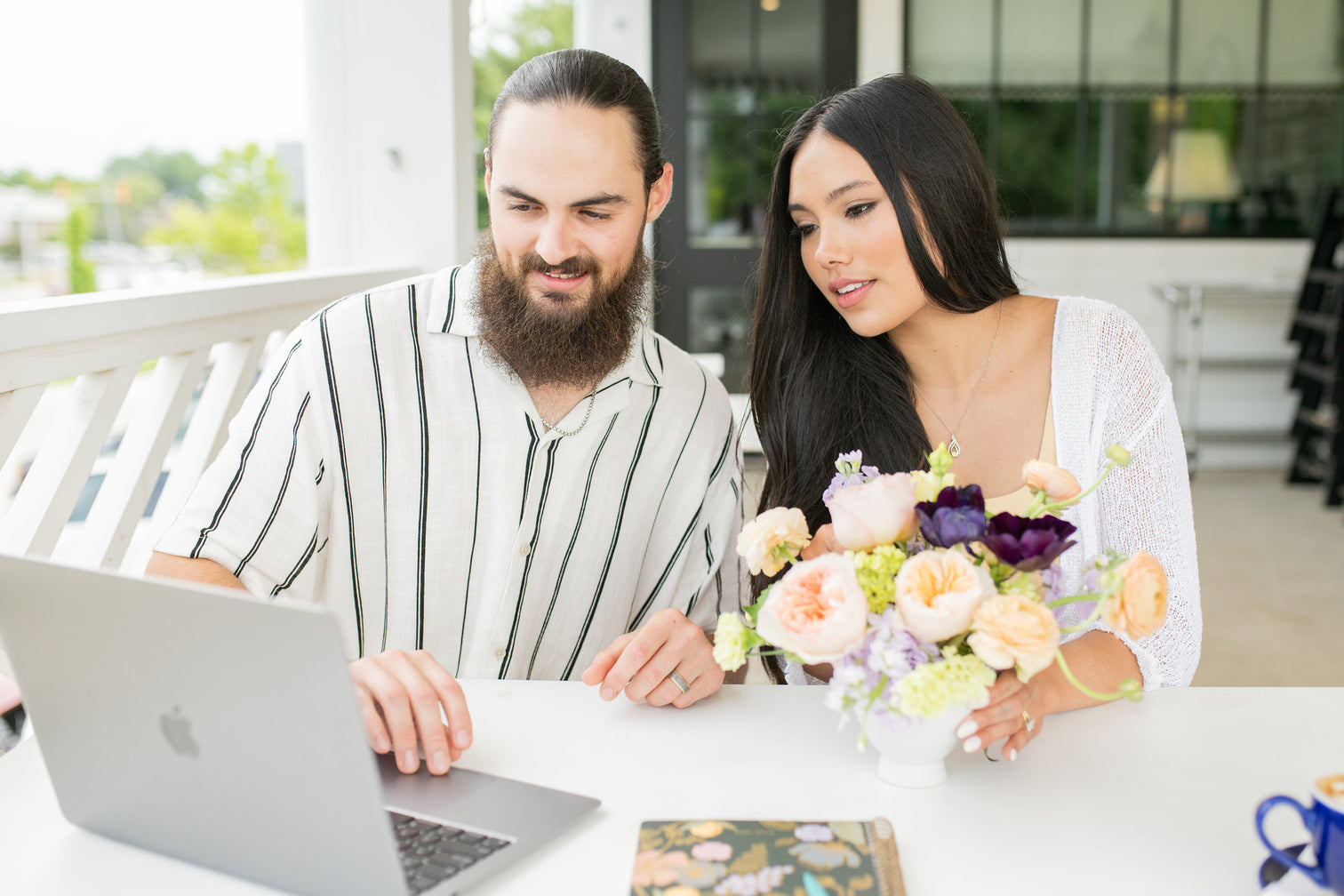 Couple looking at laptop with a floral centerpiece